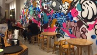 Ruangan kafe ini memanjang ke belakang. Interiornya mencuri perhatian karena tembok bermuralnya.