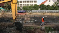 Seorang pekerja melintas di lokasi proyek revitalisasi Kali Krukut.