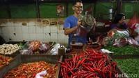 Seorang pedagang melayani pembeli.