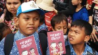 Dua bocah SD memegang brosur yang berisikan tentang program yang telah dilakukan mulai dari pemberantasan pungli, TransJakarta gratis hingga pembangunan Ruang Publik Terpadu Ramah Anak (RPTRA).