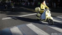 Warga menggunakan skuter listrik sebagai moda transportasi.
