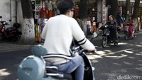 Skuter listrik dan sepeda listrik melintas di jalanan di kota Suzhou.