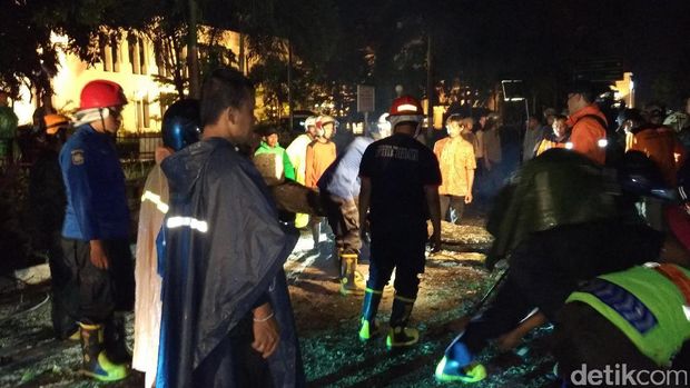 Petugas gabungan memotong batang pohon yang tumbang di Jl Senopati, Yogyakarta, Senin (21/11/2016)