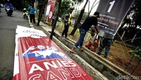 Spanduk cagub-cawagub DKI itu diikatkan di pagar pembatas jalan.