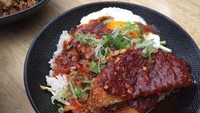 Kalau suka hidangan Korea bisa cicip Korean Clucker. Nasi putih dilengkapi chicken katsu, telur setengah matang, kimchi, saus BBQ Korea, dan bawang goreng.