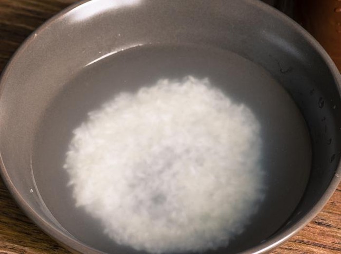 membuat tepung beras Raw rice and flour in bowls with scoop on wooden background