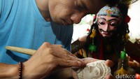 Seorang perajin mengerjakan pembuatan Topeng Malangan di Padepokan Asmoro Bangun, Kecamatan Pakishaji, Kabupaten Malang.