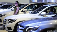 SPG berjaga di depan mobil Mercedes-Benz yang dipamerkan.