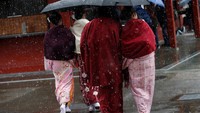 Sejumlah wanita berpakaian kimono tengah berjalan menerobos salju di distrik Asakusa, Tokyo. REUTERS/Toru Hanai.