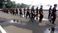 Personel Brimob melintas di depan air mancur DPR. Mereka dikerahkan ke Kompleks Parlemen tersebut untuk melakukan penjagaan.