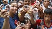 Sejumlah warga memamerkan pin bergambar Ahok-Djarot.