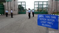 Petugas keamanan berjaga di gerbang masuk gedung DPR.