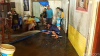 Warga di Desa Sawangan Wetan, Kecamatan Patikraja, membersihkan lumpur di dalam rumahnya.