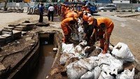 Puluhan pasukan oranye bahu-membahu membersihkan kotoran di selokan yang berada di kawasan Sudirman, Minggu (27/11/2016).