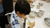 Anak-anak mencampurkan bahan untuk ravioli. Kemudian memasukkanya ke dalam adonan pasta dan melipatnya.