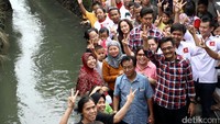 Djarot foto bersama warga di gang yang berada di samping sungai. Mereka kompak mengacungkan dua jarinya.