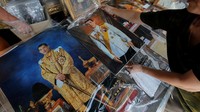 Seorang pedagang tengah menyusun foto dari Maha Vajiralongkorn. REUTERS/Jorge Silva.