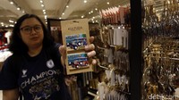 Warga menunjukan souvenir yang akan dibeli.