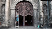Petugas tengah melakukan perawatan bagian pintu gereja.