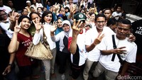 Sandiaga dan Helmalia foto bersama warga. Mereka kompak mengacungkan tiga jarinya.