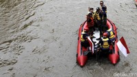 Agus menyusuri sungai Ciliwung sambil mengacungkan telunjuknya.