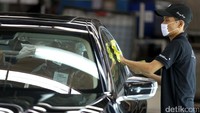 Pekerja membersihkan BMW 730Li yang selesai dirakit.
