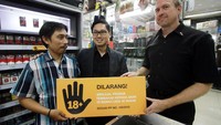Direktur Penjualan PT HM Sampoerna Tbk Ivan Cahyadi (kanan) dan Director Corporate Affairs Troy Modlin (tengah) secara simbolis menyerahkan tanda larangan penjualan rokok kepada anak dibawah usia 18 tahun kepada Pengelola TwelveMart Sobri, di Jakarta, Rabu (30/11).
