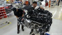 Dua orang pekerja merakit mesin BMW 730Li.