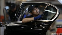 Seorang pekerja merakit pintu BMW 730Li.
