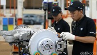 Dua orang pekerja memasang rem BMW 730Li.