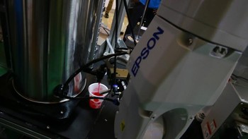 Robot C8 series menuangkan air dari dispenser ke dalam gelas.