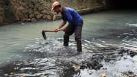 Petugas mengeruk lumpur yang mengendap di sungai.