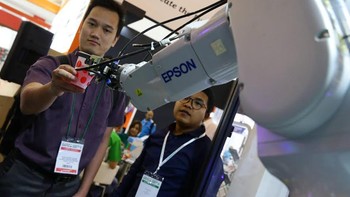 Robot C8 series menyerahkan gelas berisi air minum kepada pengunjung pameran.