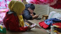 Sepi pembeli, dua orang penjual terlihat asyik bermain handphone.