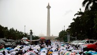 Walapun hujan deras mengguyur, tak menyurutkan niat peserta aksi untuk beribadah. REUTERS/Darren Whiteside.