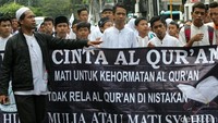 Massa membawa atribut aksi berupa spanduk.