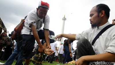 Massa Aksi 2 Desember Salat Jumat di Bawah Guyuran Hujan