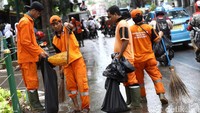Pasukan oranye membersihkan sampah sampah di sekitar Monas.