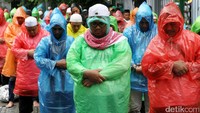 Massa aksi damai 2 Desember salat menggunakan jas hujan warna-warni.