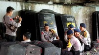 Polisi berjaga dengan membawa perlengkapan pengamanan seperti tameng.