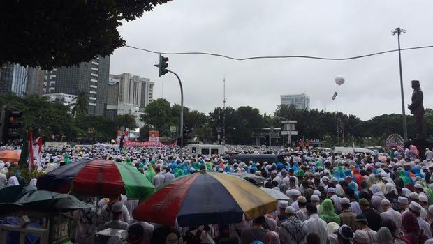 Massa menggunakan jas hujan.