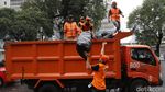 Pasukan Oranye Bersihkan Sampah di Kawasan Monas