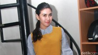 Ia terlihat kasual dengan kemeja biru bergaris, outer berwarna oranye, ripped jeans dan sepatu hitam dengan hiasan payet. Pool/Gus Mun/detikFoto.