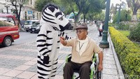 Zebra cross tersebut nampak membantu seorang kakek penyandang disabilitas.