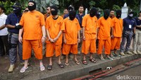 Para tersangka menyaksikan pemusnahan barang bukti narkoba dengan tangan diborgol.