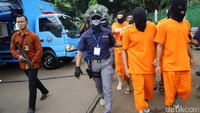 Para tersangka dihadirkan dalam pemusnahan narkoba dengan memakai baju tahanan. Mereka juga memakai penutup kepala.