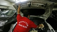 Petugas Rumah Penyimpinan Barang Sitaan Negara (Rupbasan) mengecek mesin mobil sitaan KPK.
