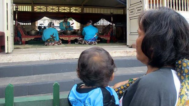 Masyarakat mendengarkan irama gamelan yang ditabuh para abdi dalem.