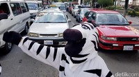 Walaupun hanya memakai kostum zebra, cara tersebut cukup menyita perhatian sejumlah pengendara.