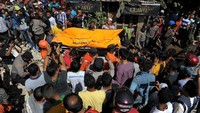 Tim SAR mengevakuasi korban tewas dari reruntuhan bangunan. Chaideer Wahyudin/AFP/detikFoto.